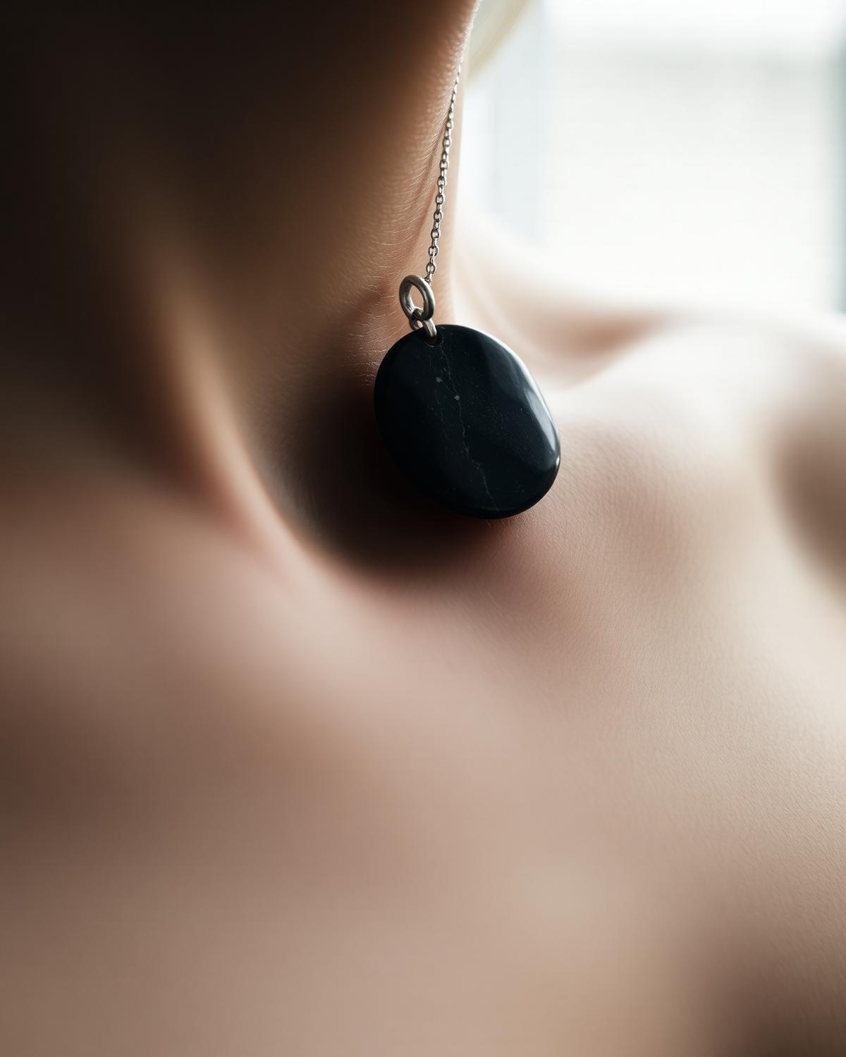 Ett mörkt stenhalsband som vilar mot huden i mjukt naturligt ljus